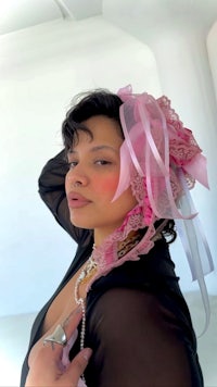 a woman wearing a pink hat and pearls