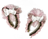 a pair of pink and white hair clips with bows