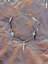 a necklace with a cross and pearls on it