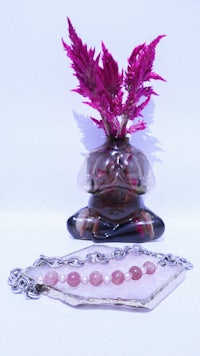 a vase with a pink flower in it