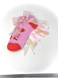 a pair of pink socks with bows and ribbons